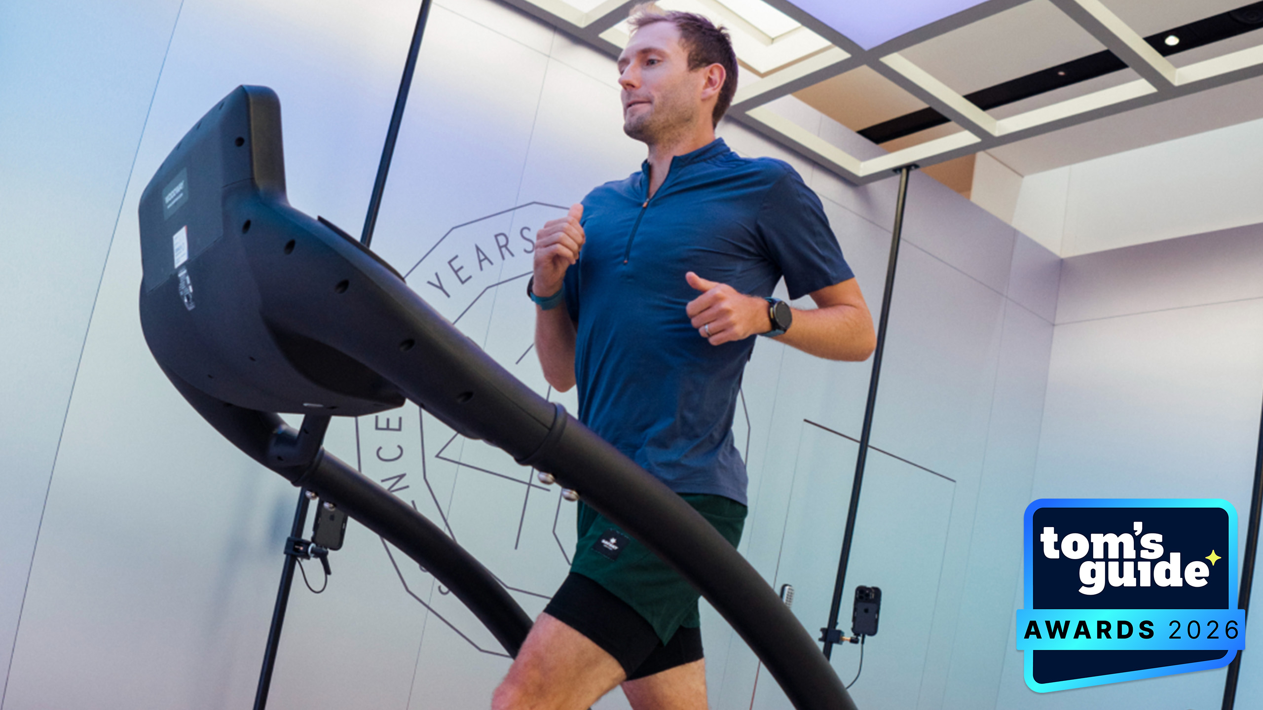 A person running on a treadmill with Nike outerwear on with a TG Awards 2026 badge