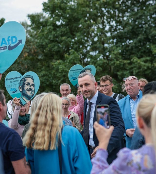 Far-right Alternative for Germany (AfD) party's main candidate Ulrich Siegmund greets supporters as he arrives for a debate on MDR regional TV in Magdeburg, eastern Germany on August 26, 2026. Saxony-Anhalt will go to the polls in the regional elections on September 6, 2026. (Photo by Ronny HARTMANN / AFP via Getty Images)