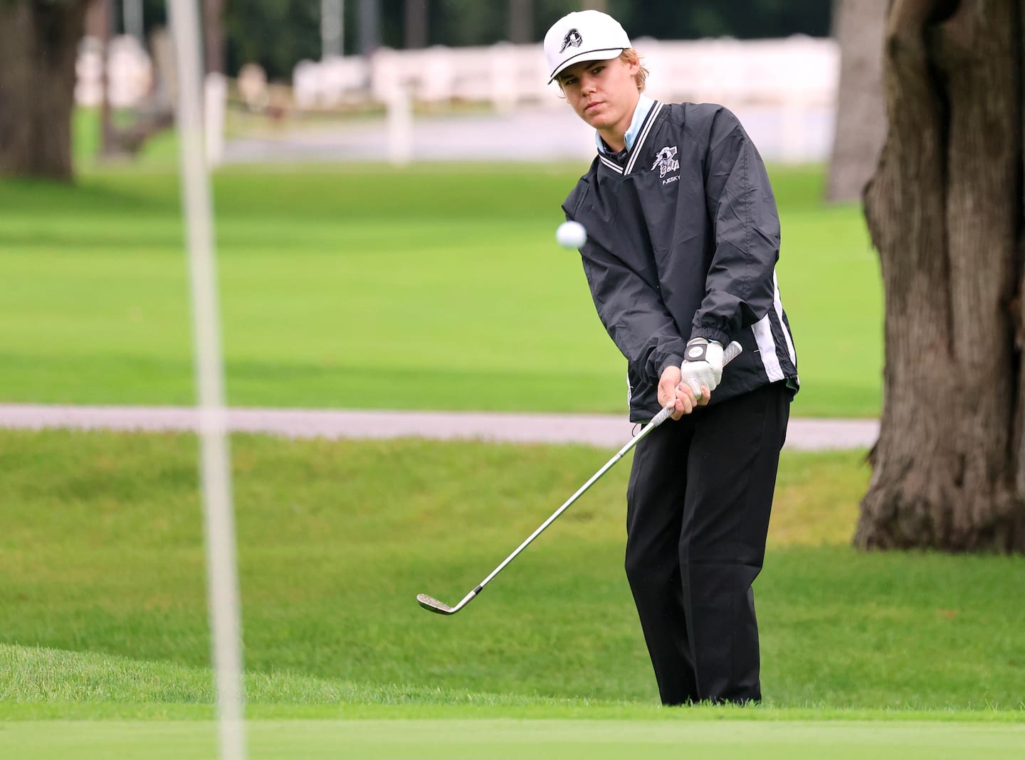 Kaneland’s Dylan Pjesky chips onto the green Tuesday, Sept. 22, 2026, during the Interstate 8 boys golf championship at Sycamore Golf Club.