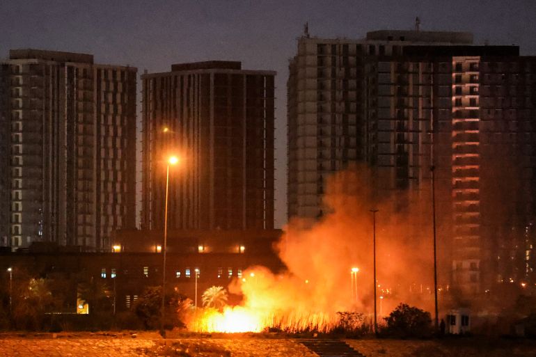 CORRECTION / A fire burns outside the grounds of the US Embassy headquarters in Baghdad's fortified "Green Zone" on March 17, 2026 following a drone and rocket attack according to security officials.