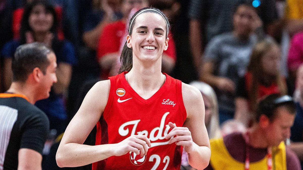 Caitlin Clark, wearing Indiana Fever uniform number 22, stands before a game against the Connecticut Sun.