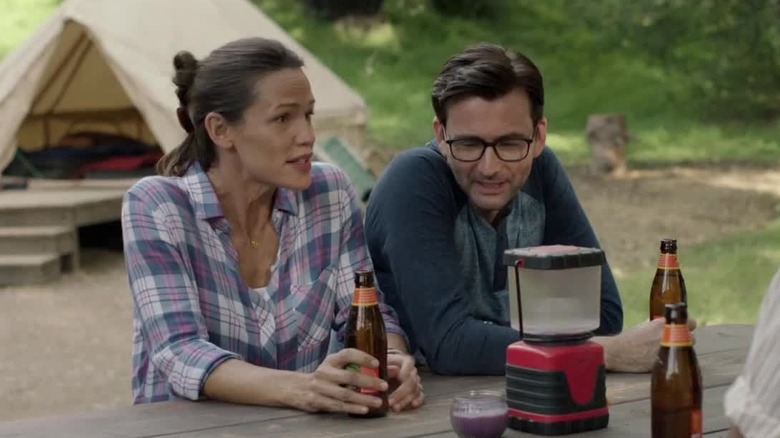 Jennifer Garner and David Tennant as Kathryn and Walt sitting at a table drinking in Camping