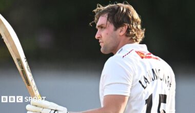 Tom Lammonby raises his bat in his left hand with his helmet off and in his right hand after passing 100 for Somerset