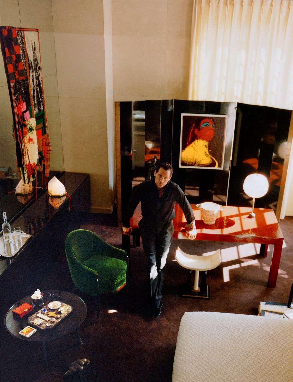 A stylish interior featuring a person, modern furniture, and artwork in a well-lit room.