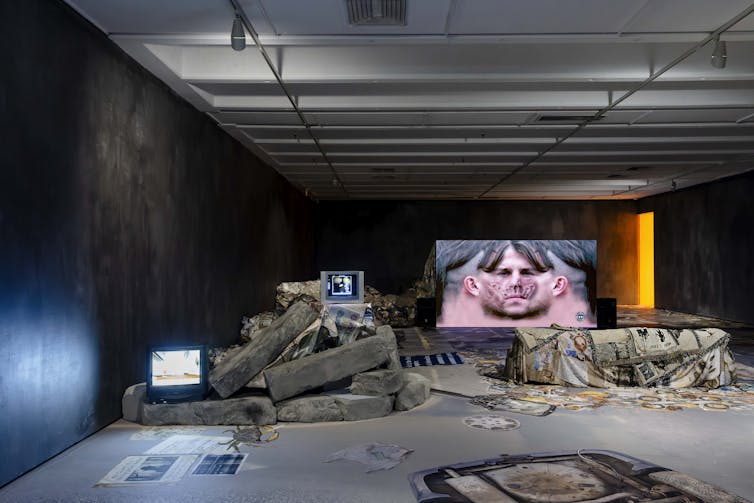 TVs, and screens amid detritus.
