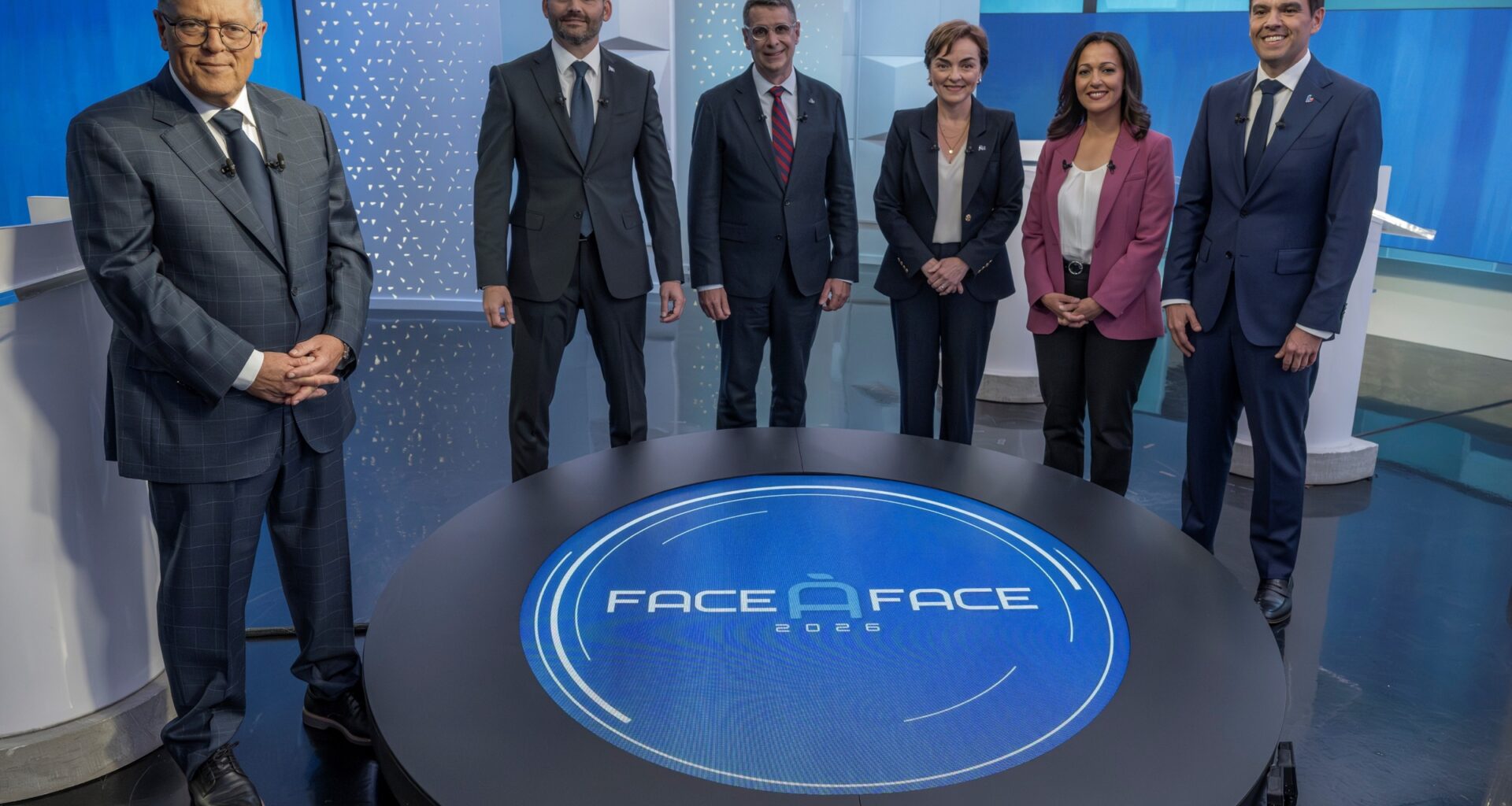 Five party leaders stand near Paul Larocque in a TV studio posing for a photo.