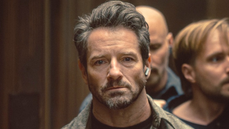 Ian Bohen as Grady in Lioness, looking ahead with earpiece in left ear