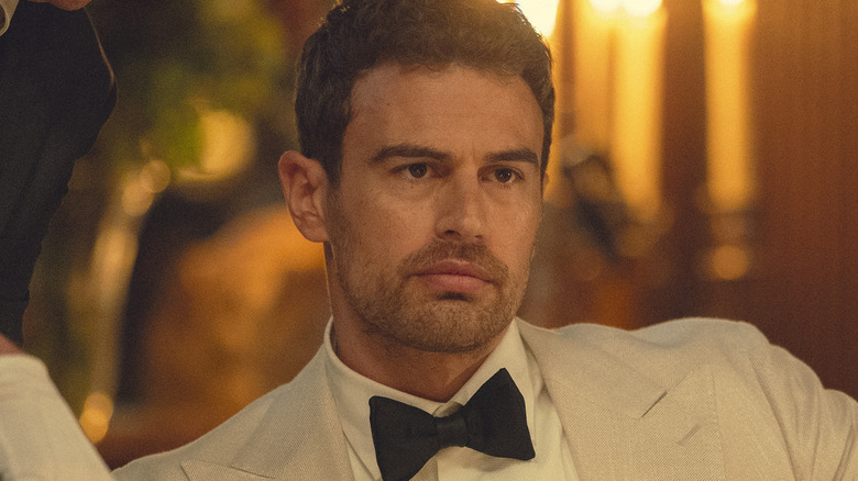 Eddie Horniman (Theo James) sits in a white tuxedo in The Gentlemen