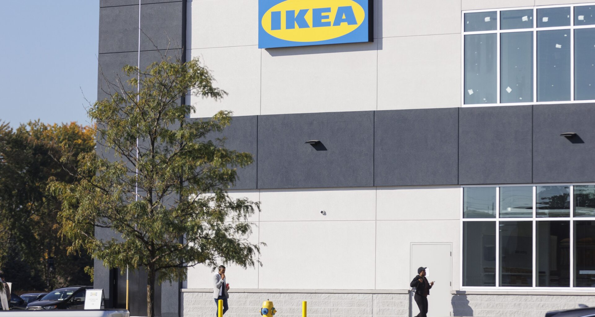 Customers walk past the sign for the new Ikea store