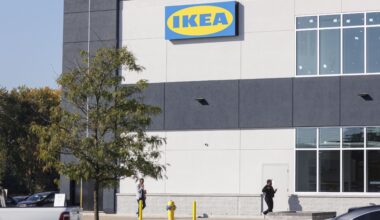 Customers walk past the sign for the new Ikea store