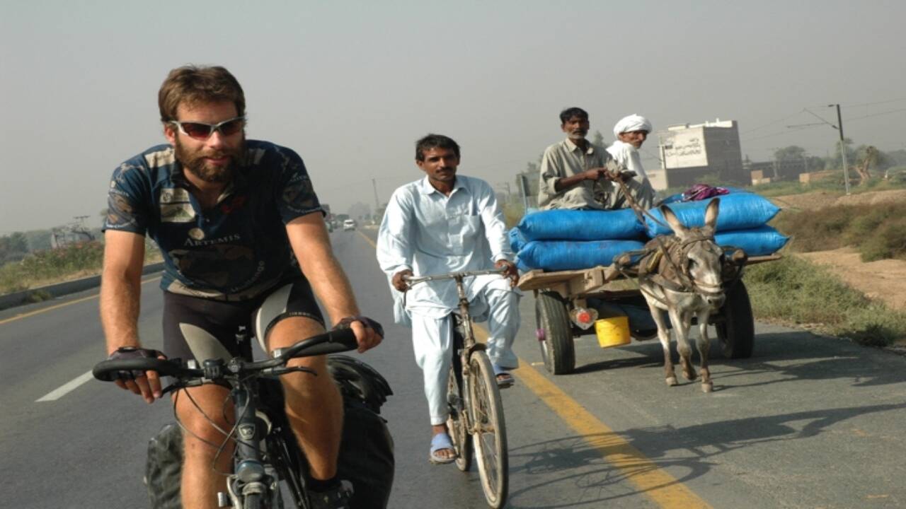 Mark Beaumont cycles alongside a local rider and a donkey-drawn cart in eastern Pakistan during his 2007–08 record-setting journey around the world by bicycle. Credits - Wikipedia Mark Beaumont<br>