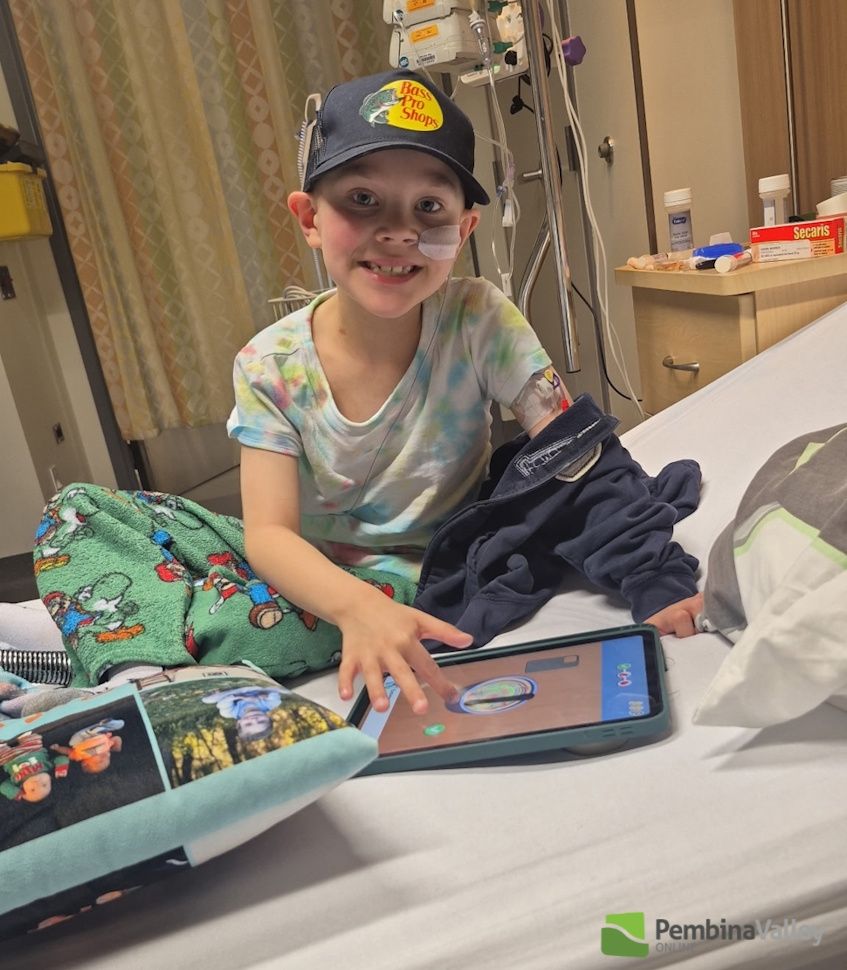 Maverick in a hospital bed with a tablet