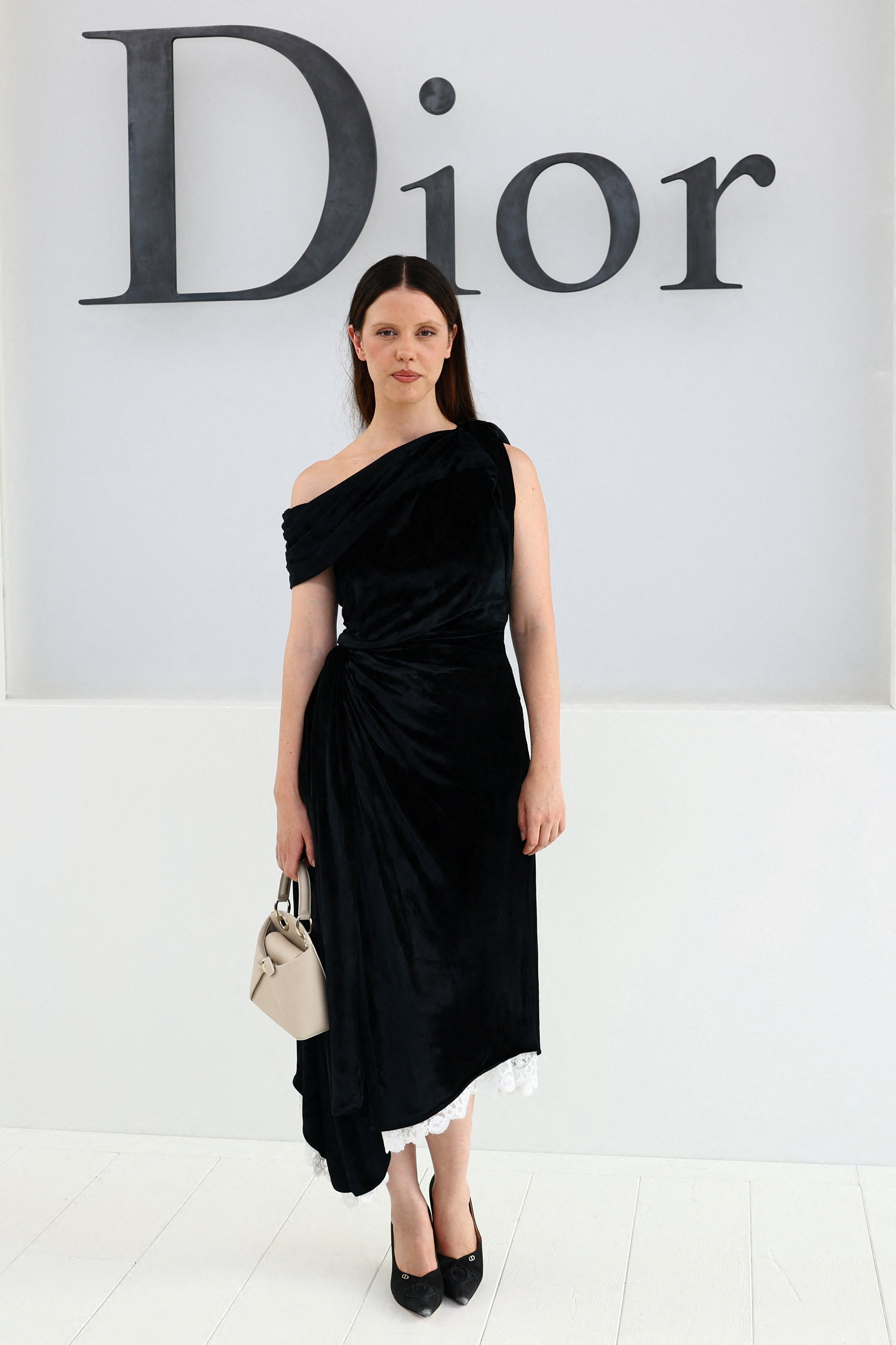 Mia Goth in a black velvet dress poses before the Dior Spring/Summer 2027 show.