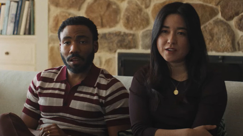 Donald Glover and Maya Erskine as John and Jane sitting on a couch together in Mr & Mrs Smith