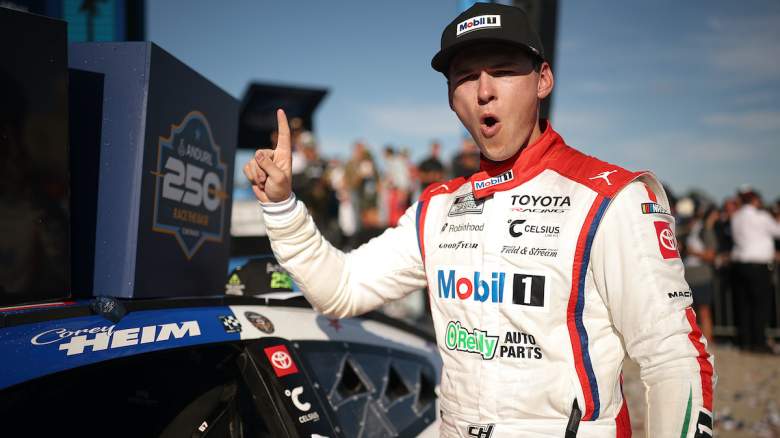 Corey Heim, driver of the #67 Mobil 1/O'Reilly Auto Parts Toyota, poses with the winner sticker on his car in victory lane