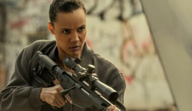 young black woman with hair pulled back in combat gear and holding a high-powered rifle in her hands