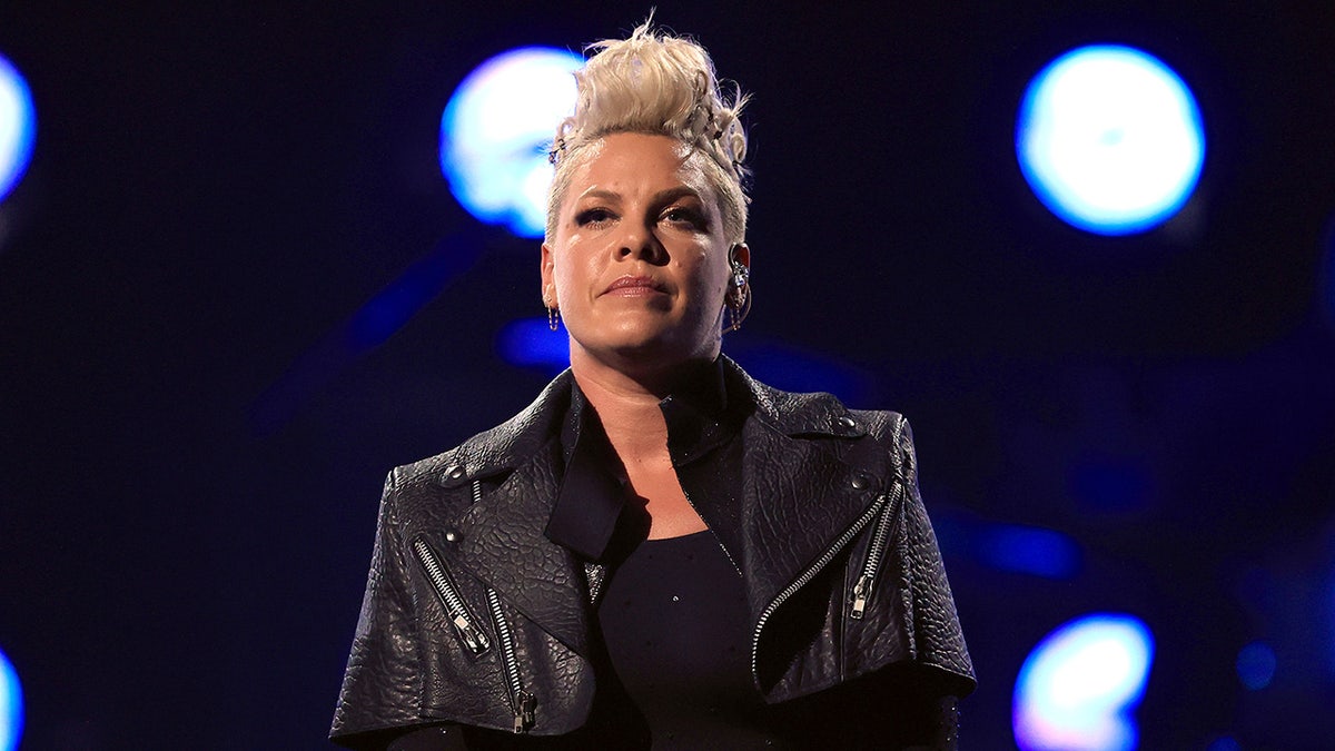 Singer Pink sports blonde hair and wears a black jacket