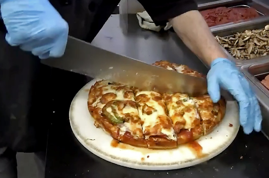 A pizza being cut at Tumblers Pizza in Regina.
