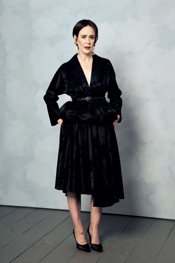 Sarah Paulson posing in a black peplum top and skirt.