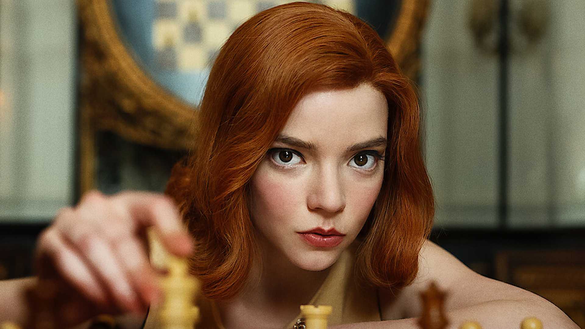 Anya Taylor-Joy as Beth Harmon in The Queen's Gambit moving a chess piece and looking toward the audience.