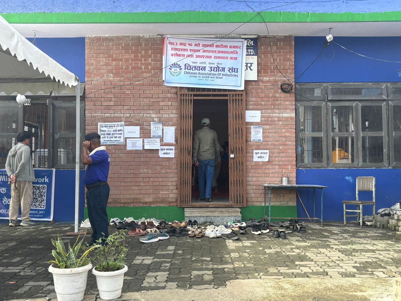 People stand in front of the Nepal Poultry Entrepreneurs Forum (NPEF) in Bharatpur, Nepal on Tuesday.