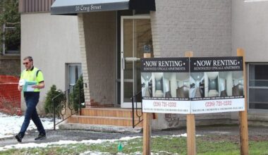 for rent sign is displayed outside an apartment building