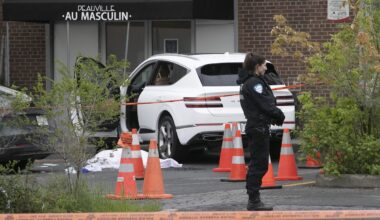 Montreal police stand near the body of Claudia Iacono near a car with projectiles holes in side window.