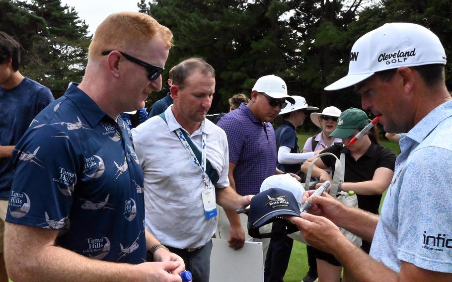 A professional golfer signs a golf cap