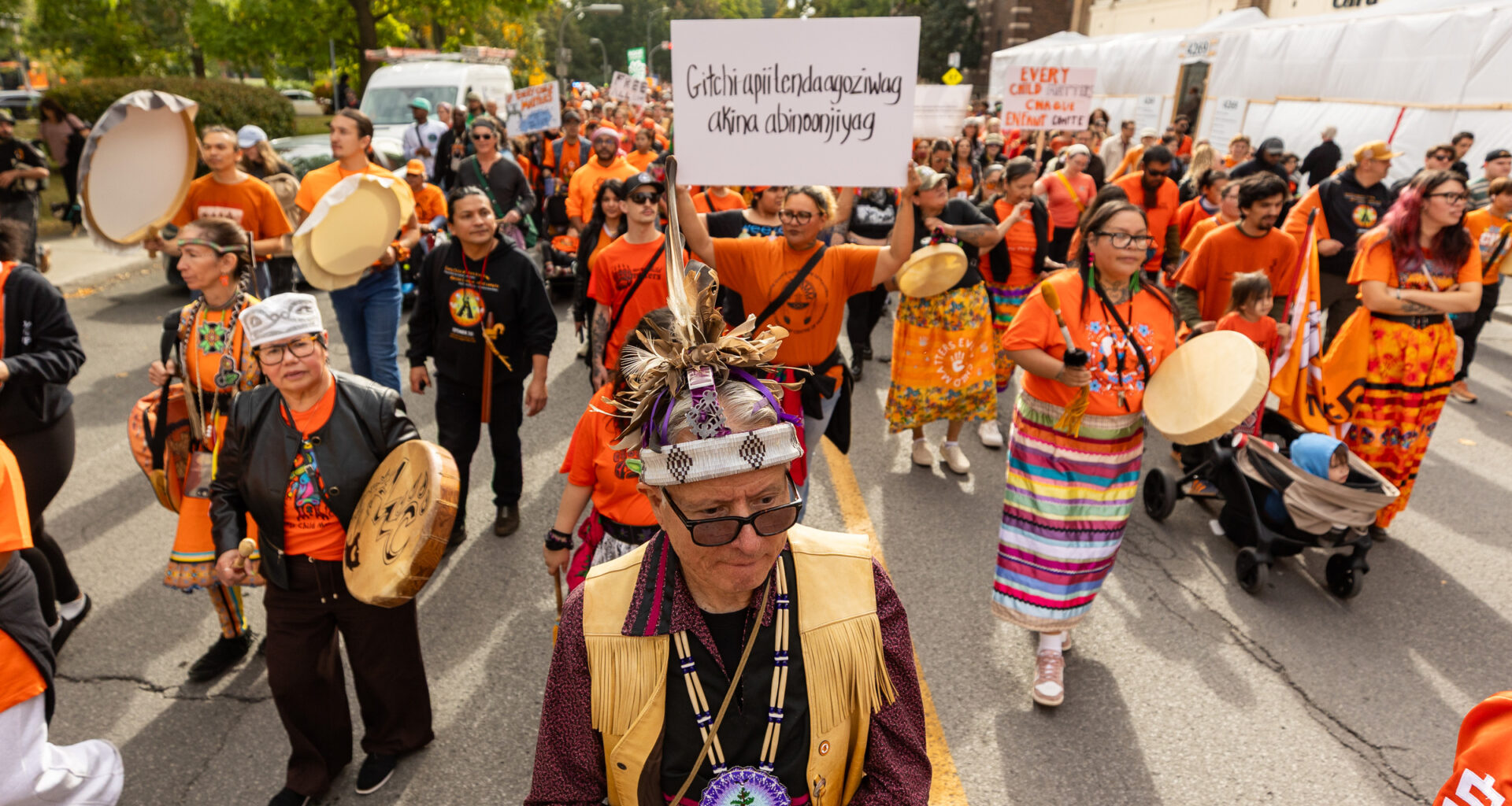 People in orange T-shirts march in a street