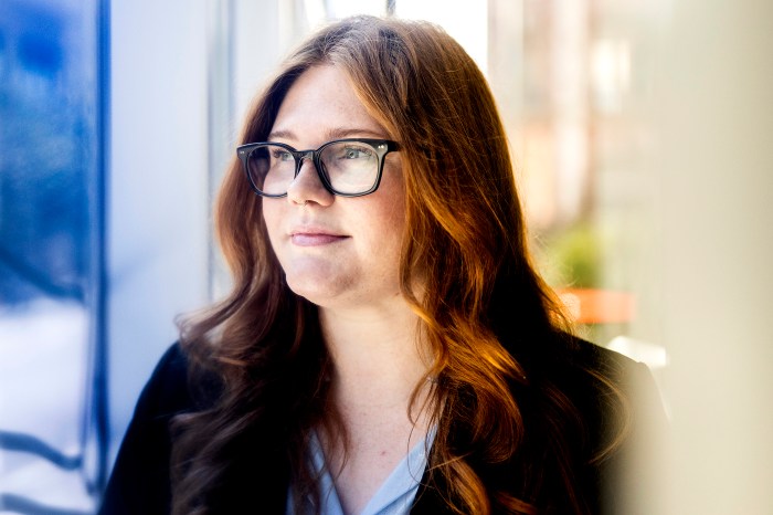 Savannah Reid, wearing glasses, looks off into the distance. 