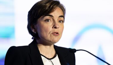 A woman speaks into microphone on stage.