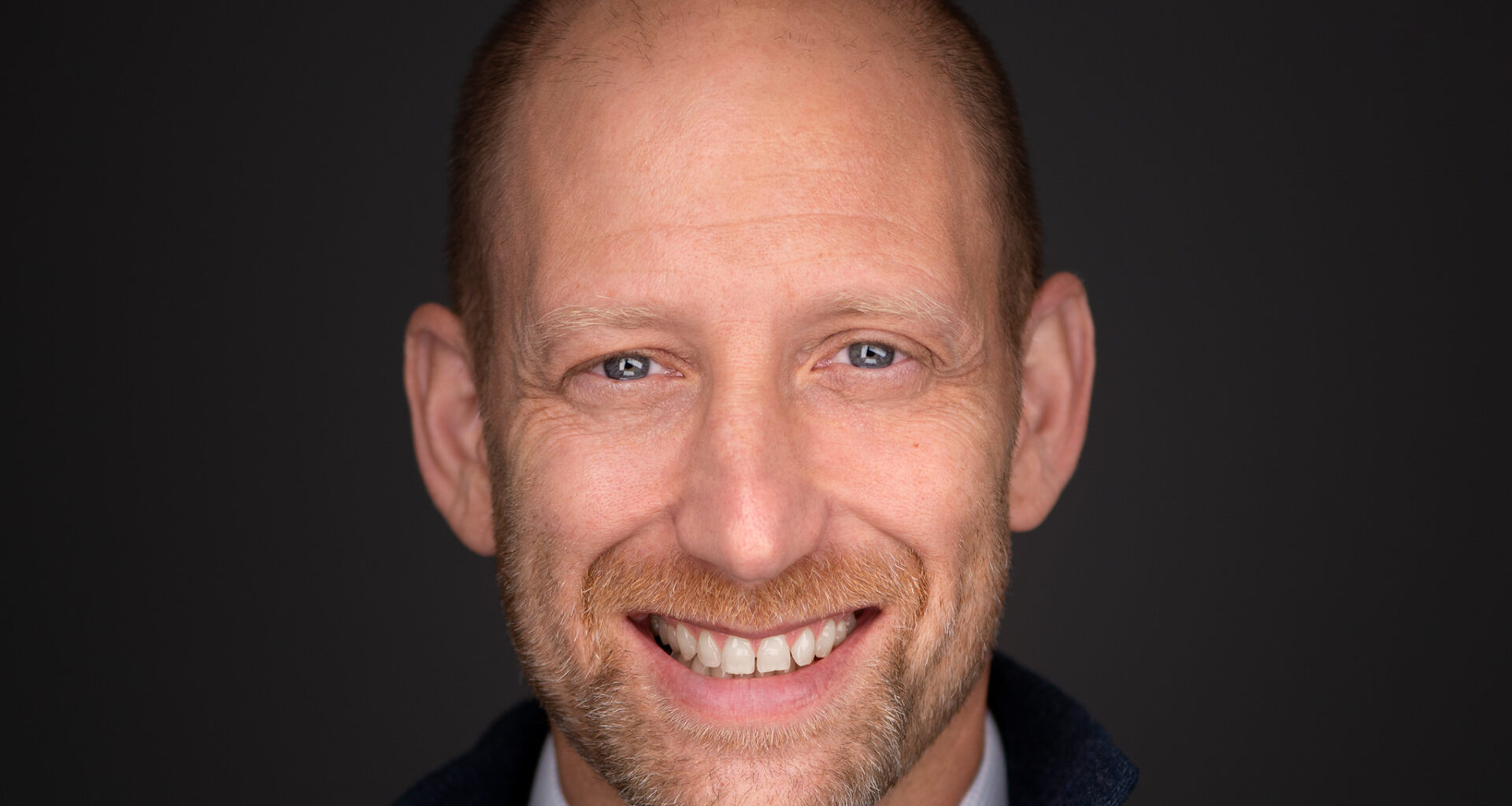 A man smiles in a promotional photo