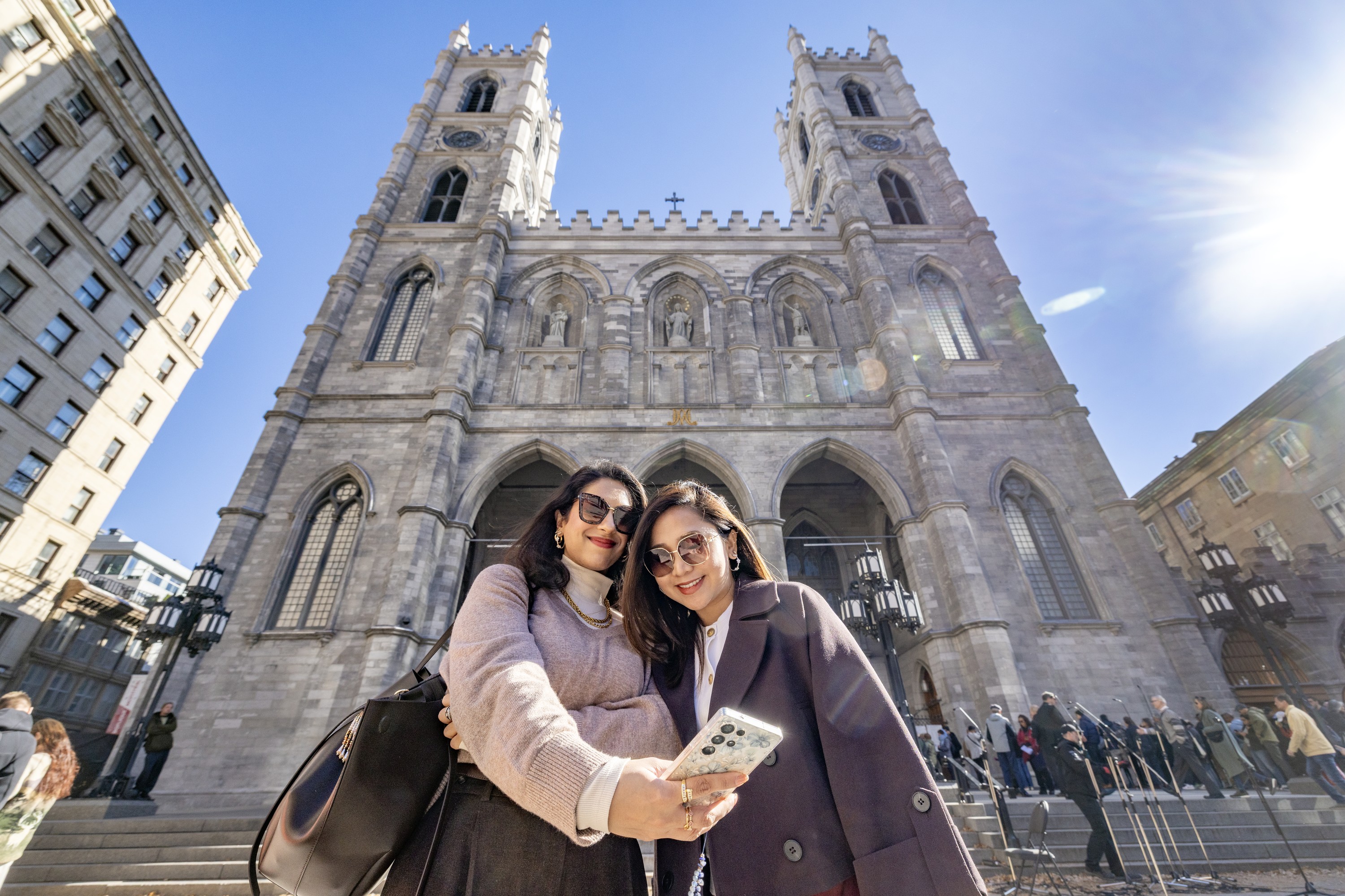 Saadia Ahmad, left, and Claudine Tinio, visiting from Toronto, take a selfie in front of Montreal's Notre-Dame Basilica
