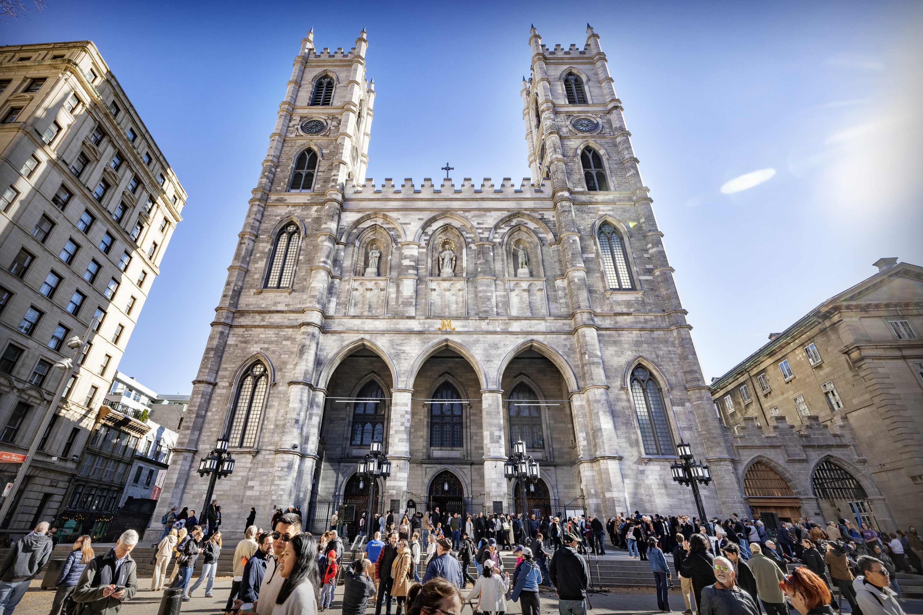 People flood the street in front of Montreal's Notre-Dame Basilica after an event marking the unveiling of the facade after years of restoration
