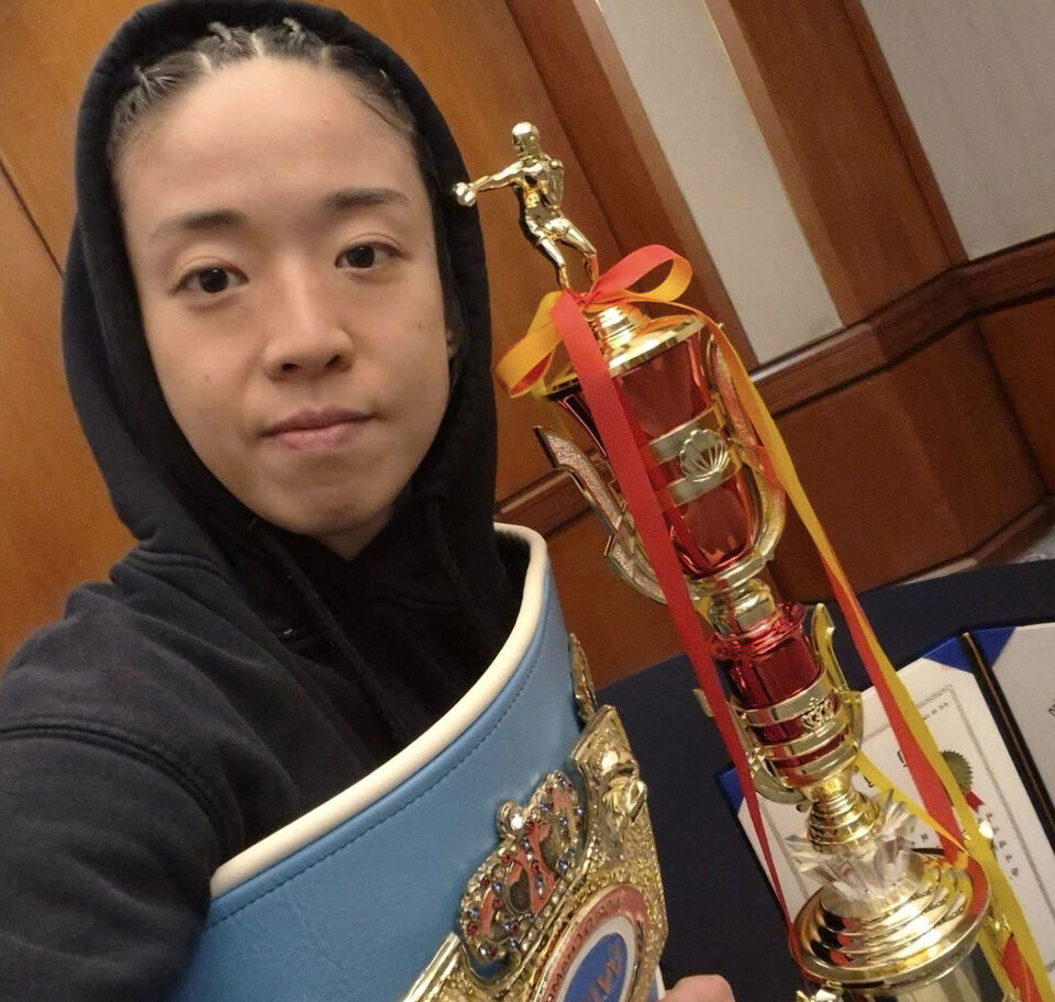 소아청소년과 전문의이자 프로복서인 서려경이 챔피언 벨트를 두른 채 우승 트로피와 함께 기념사진을 찍고 있다