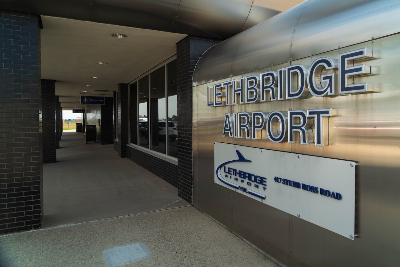 A dark hallway features a large wall sign that reads "Lethbridge Airport."