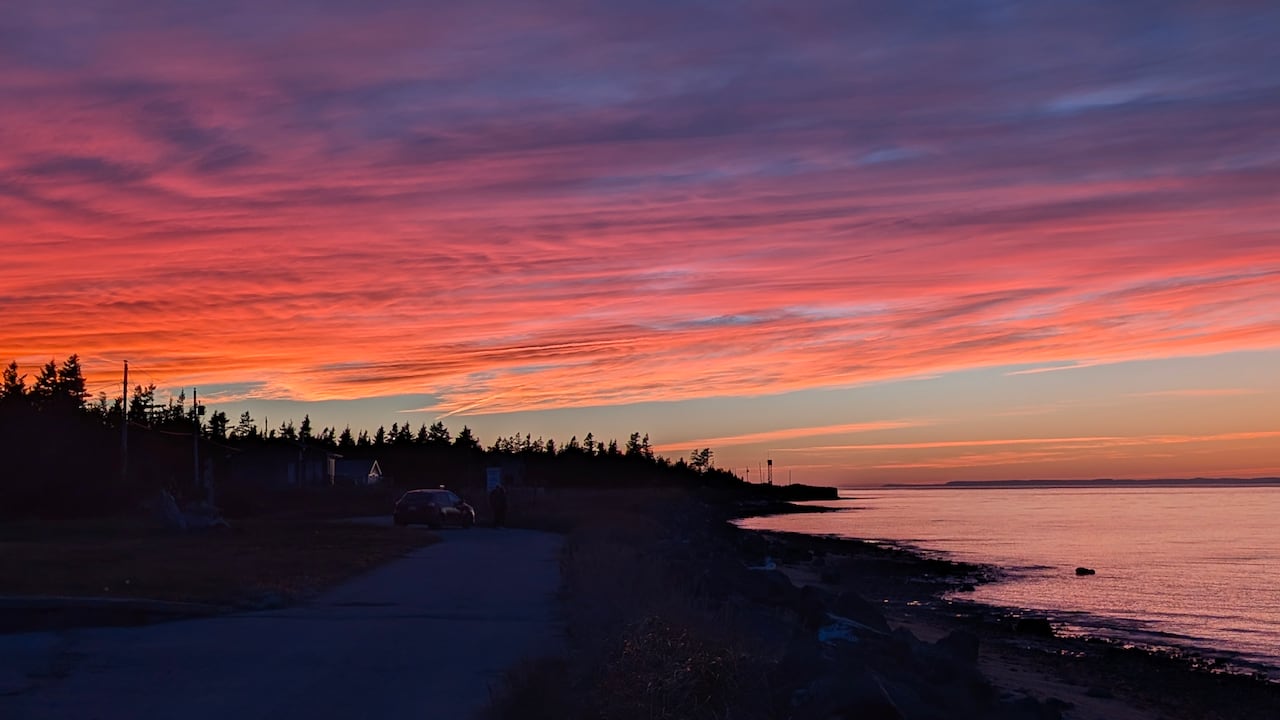 An orange and purple sunset over a bay