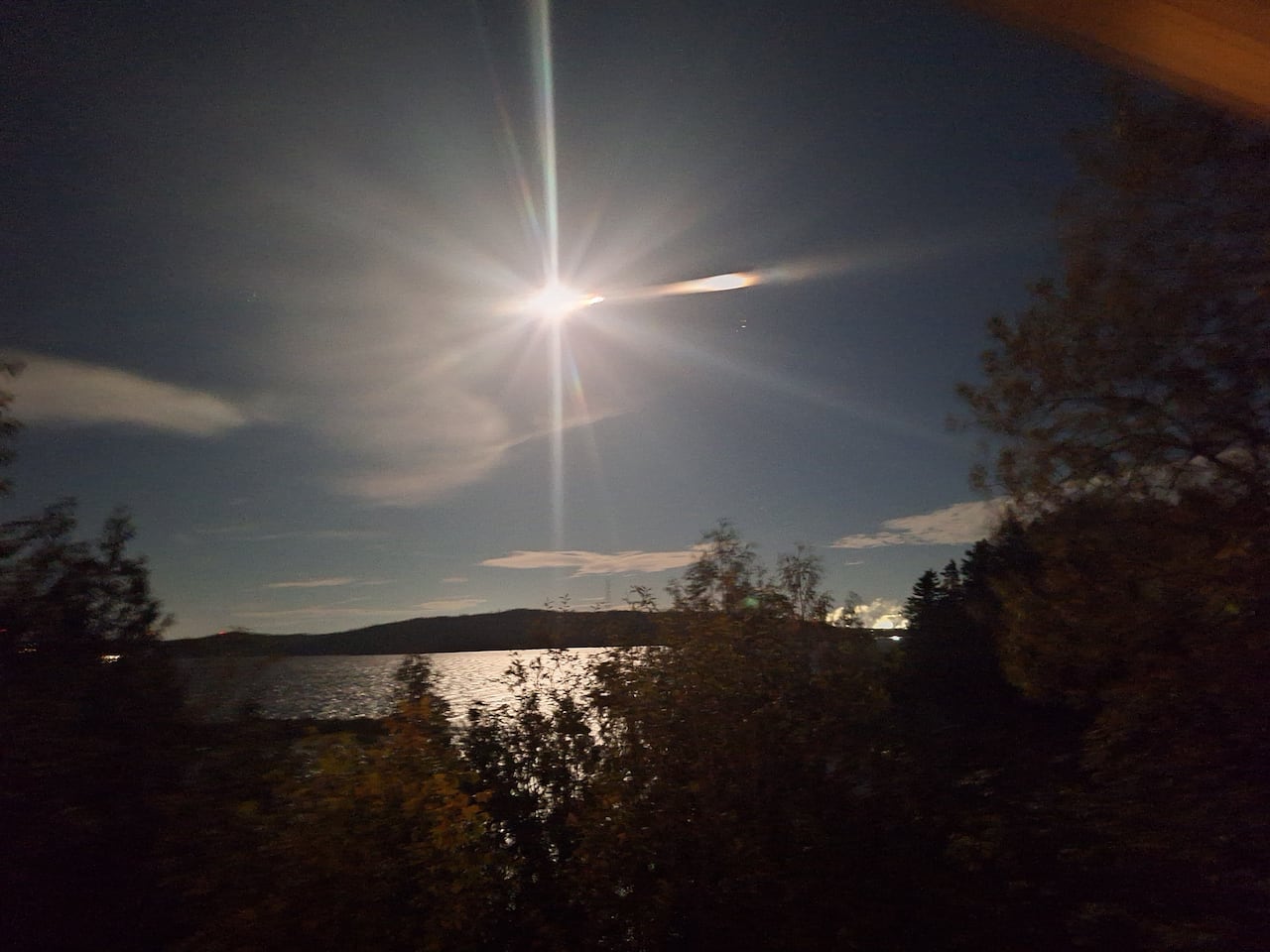 A shining bright moon over a body of water