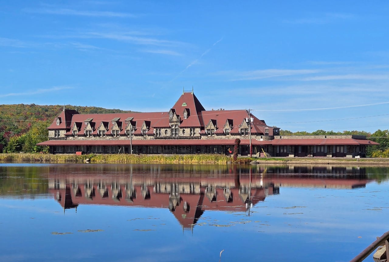 A railway station sitting on the edge of a lake under a blue sky.