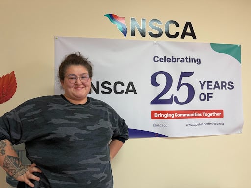 A person posing for a photo in front of a banner.