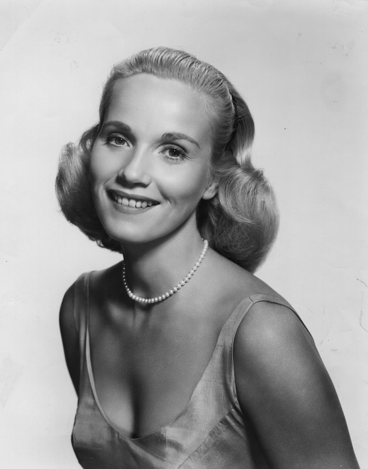 A person poses for a photograph in this black and white image.