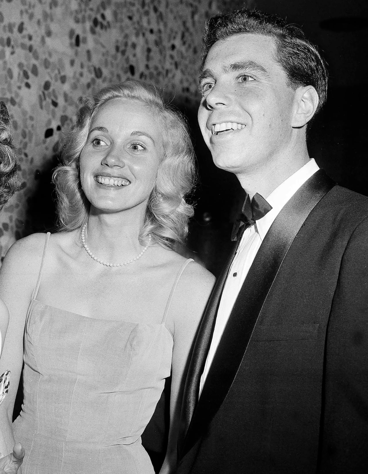 Two people are seen posing for a photograph in this black and white image.