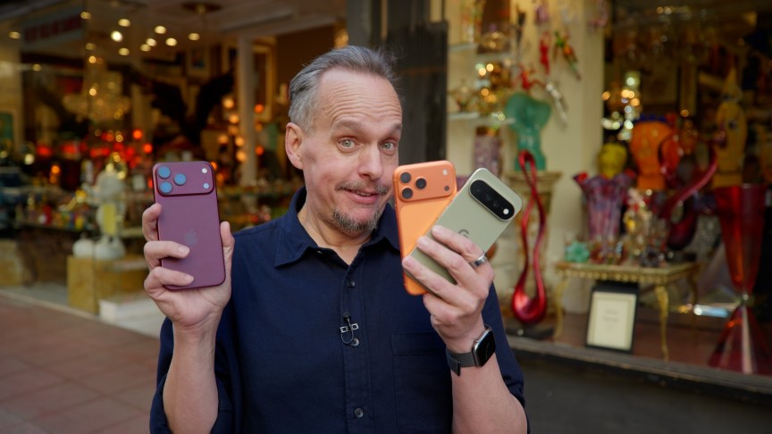 A man holding three phones