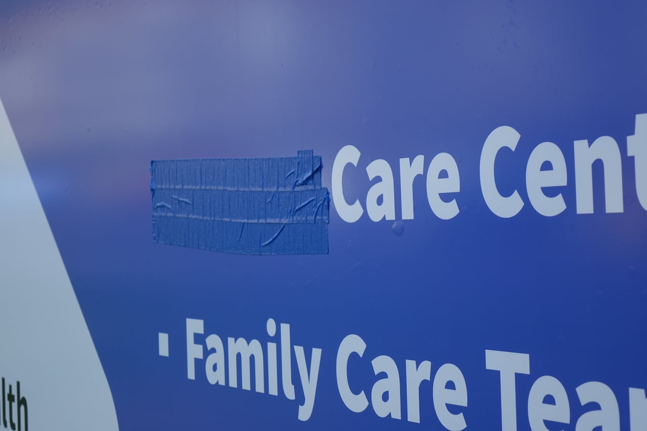 Tape covers over the word 'urgent' on the sign in front of 850 Topsail Road.