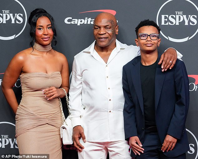 Mike Tyson and his wife Lakiha Spicer are being sued for £1.5million after the boxing legend refused to appear alongside a talking pigeon in a lucrative publicity campaign (couple pictured with their 14-year-old son Morocco Tyson, right)