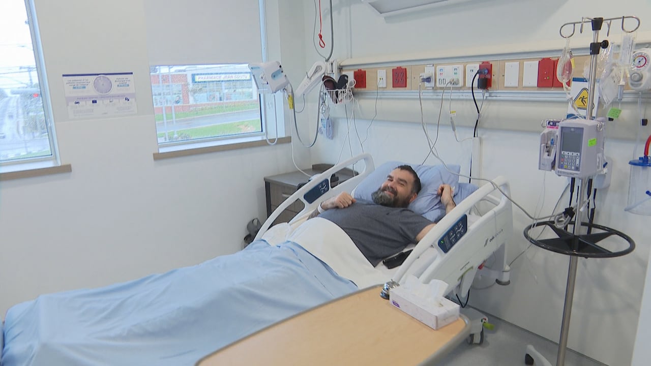 A man laying in a hospital bed in a new care room