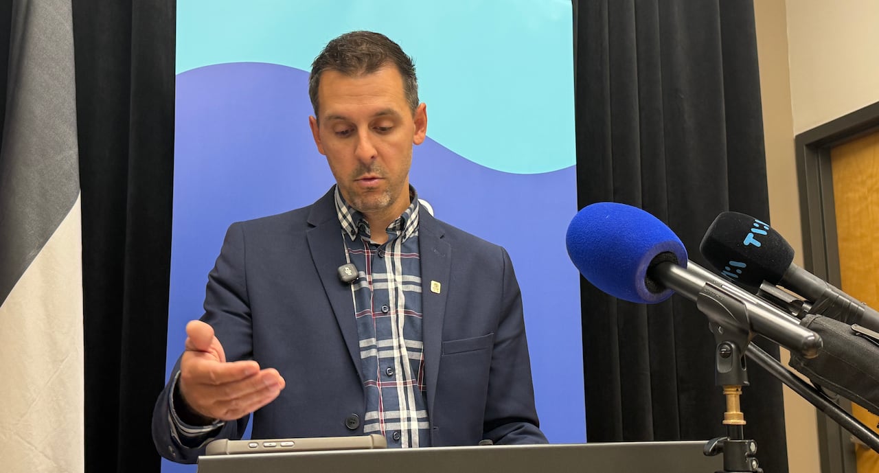 A man speaks in front of microphones