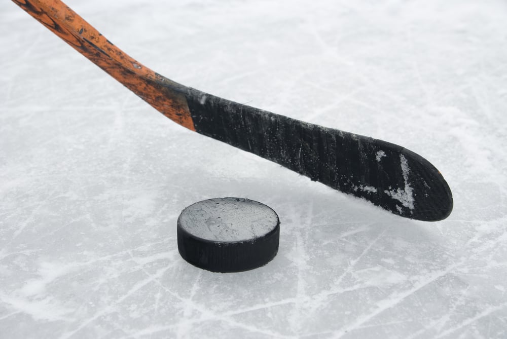 A hockey stick and puck on ice
