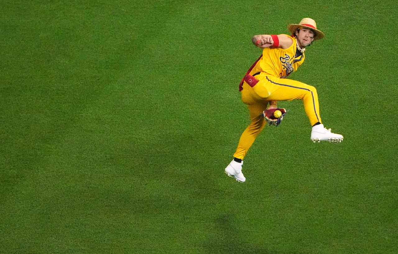 A player in yellow catches a ball between his legs.