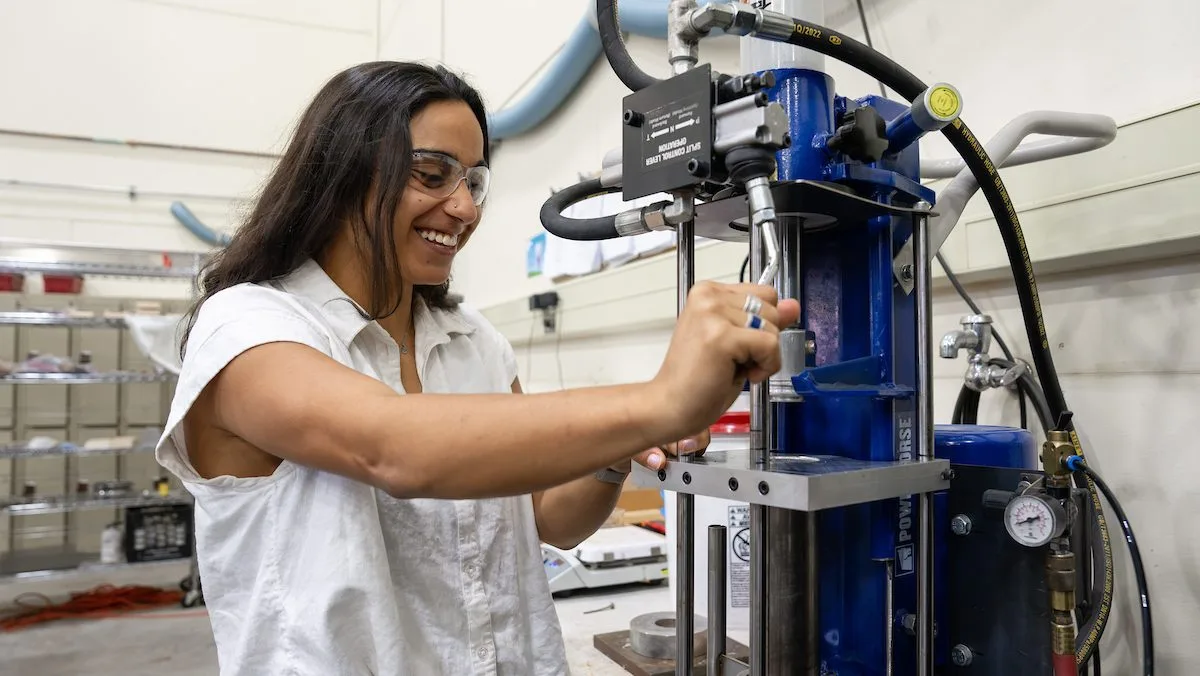 Graduate student Isabelle Irani utilizes the specialized injection molding machine designed for manufacturing the lobster-shell golf tees